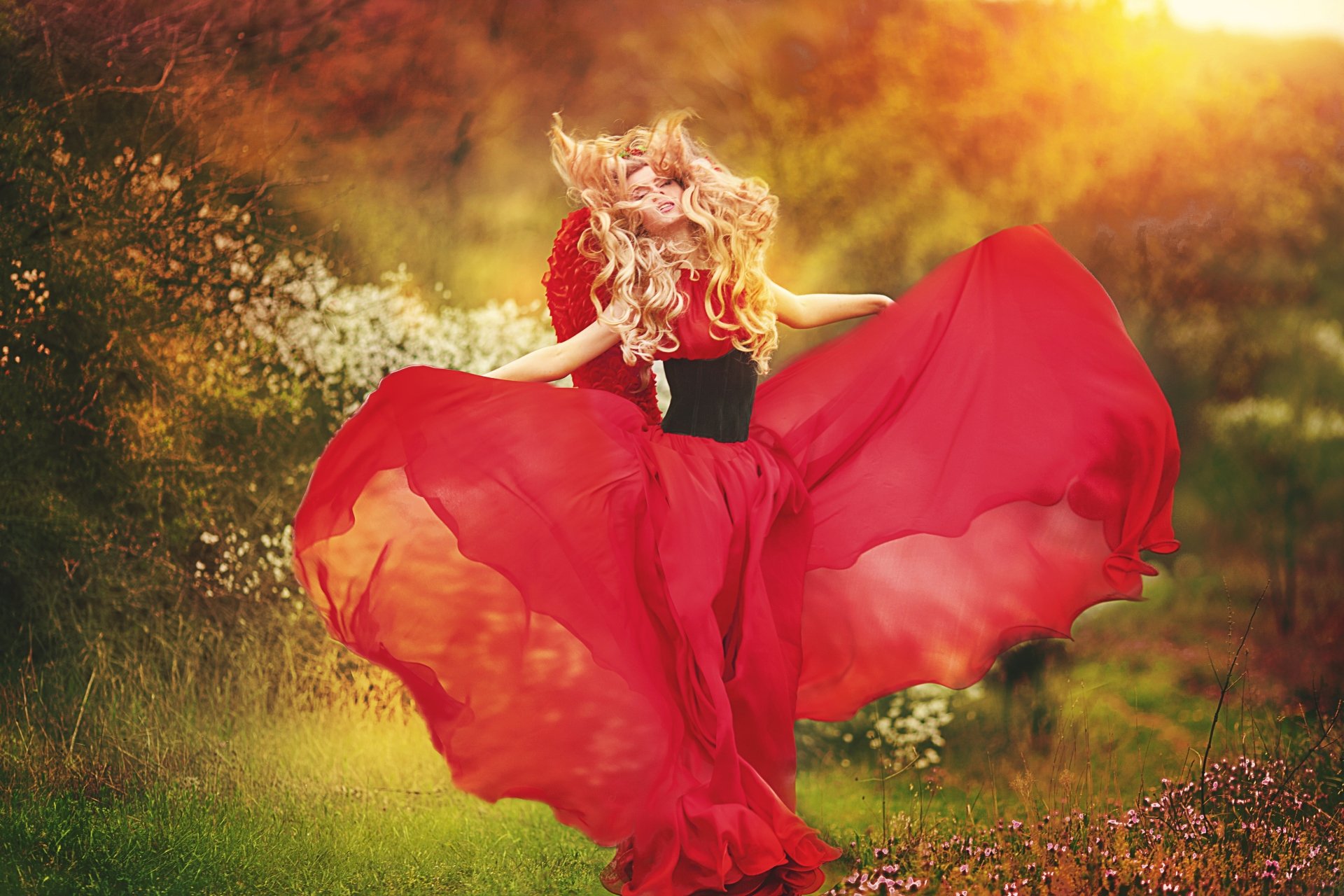 A blonde woman in a flowing red dress dances gracefully outdoors, captured in vibrant 4K Ultra HD for a striking desktop wallpaper background.