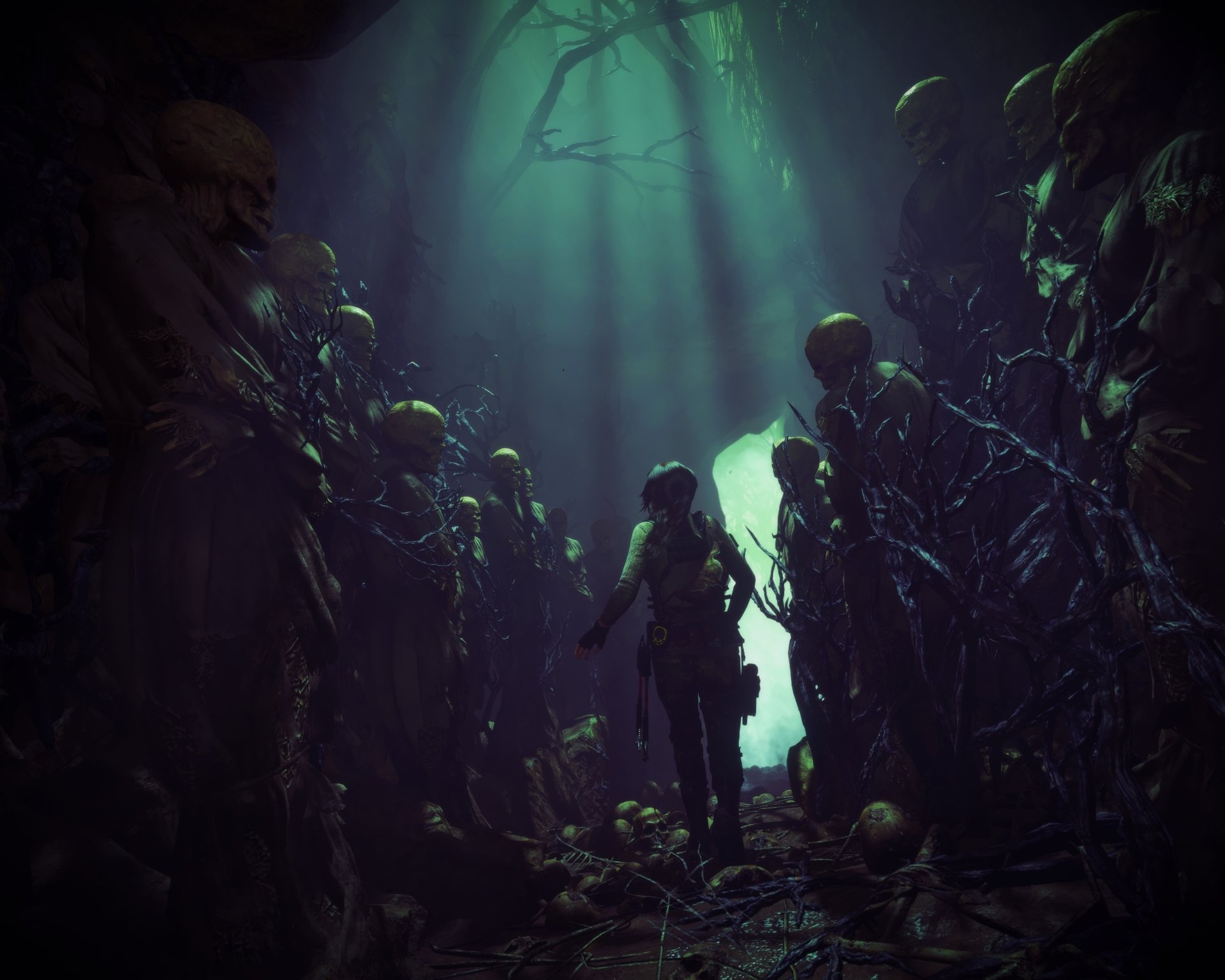 4K Ultra HD desktop wallpaper from the video game Rise of the Tomb Raider, depicting a figure standing amidst ancient skeletal statues in a dark, eerie cavern.