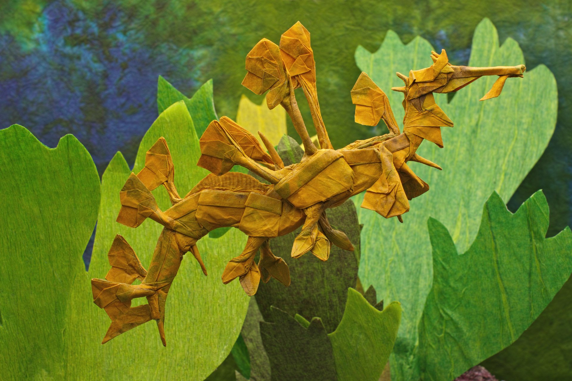 A detailed origami leafy seadragon crafted from brown paper is displayed against a green, aquatic-themed background in this 4K Ultra HD PC desktop wallpaper.