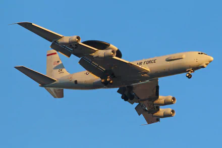 HD desktop wallpaper of a Boeing E-3 Sentry military warplane in flight against a clear sky, showcasing its distinctive radar dome and Air Force markings.