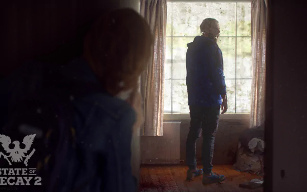 A scene from State of Decay 2 features a character in a blue jacket standing in a sunlit room, with another figure partially visible in the foreground, creating a tense atmosphere.