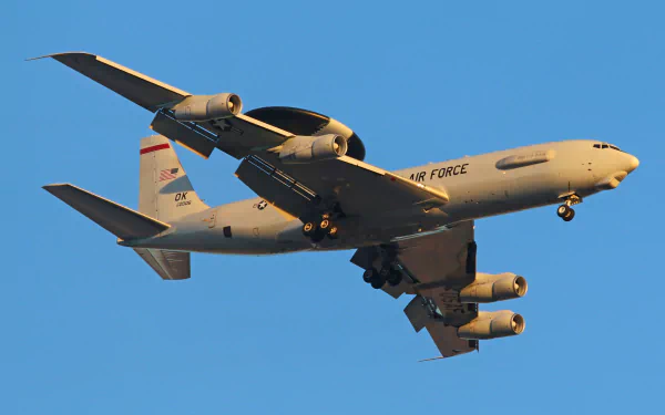HD desktop wallpaper of a Boeing E-3 Sentry military warplane in flight against a clear sky, showcasing its distinctive radar dome and Air Force markings.