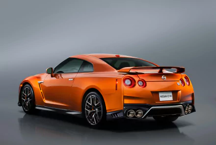 Orange Nissan GT-R supercar showcased against a sleek gray background, displayed in crisp 4K Ultra HD as a high-quality PC desktop wallpaper.