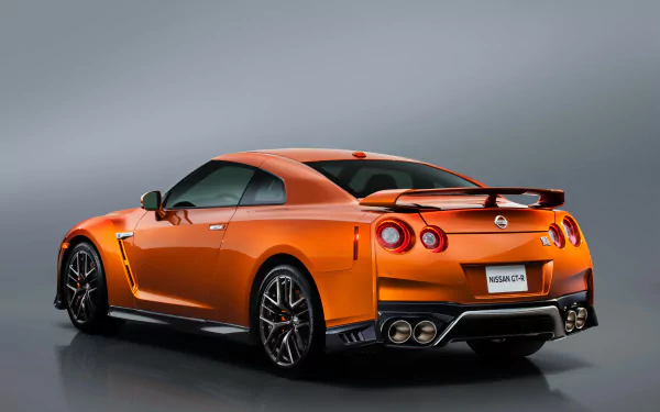 Orange Nissan GT-R supercar showcased against a sleek gray background, displayed in crisp 4K Ultra HD as a high-quality PC desktop wallpaper.