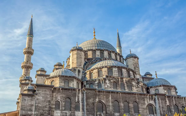 HD desktop wallpaper showcasing the Yeni Mosque in Istanbul, Turkey, featuring its iconic domes and towering minarets against a clear blue sky.