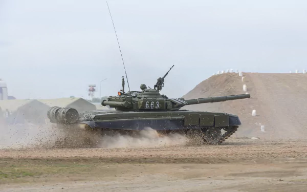 A T-72 military tank maneuvers through a dusty terrain, showcasing its power and presence. This 4K Ultra HD wallpaper captures the dynamic nature of military vehicles.