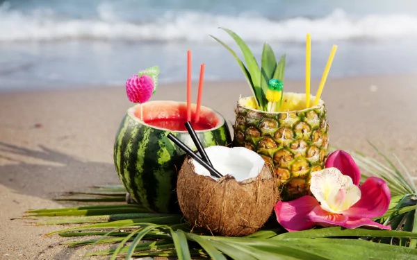 Vibrant summer cocktails served in watermelon, pineapple, and coconut on a beach, surrounded by tropical foliage, capturing the essence of a refreshing beach getaway.