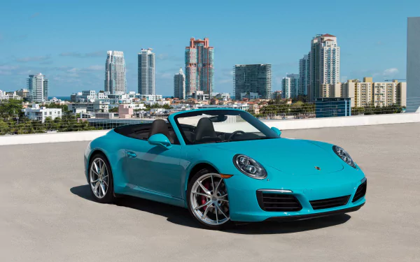 A turquoise Porsche 911 Carrera convertible parked on a rooftop with a city skyline in the background, captured in stunning 4K Ultra HD quality.
