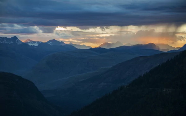 A stunning mountain landscape at dusk, featuring a vibrant sunset and dramatic clouds, creates a serene natural scene perfect for a high-definition desktop wallpaper.