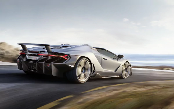 Silver Lamborghini Centenario supercar speeding along a coastal road — 2K Quad HD PC desktop wallpaper background