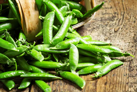 4K Ultra HD PC desktop wallpaper and background: vibrant food close-up of fresh green peas spilling from a wooden basket onto a rustic wood surface.