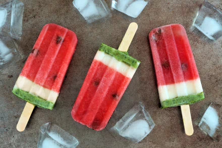 Colorful watermelon-themed ice cream popsicles surrounded by ice cubes, captured in vivid 4K Ultra HD as a refreshing summer food desktop wallpaper.