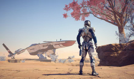 Scott Ryder stands in a vibrant extraterrestrial landscape, gazing at a sleek spaceship in the distance, from the video game Mass Effect: Andromeda. HD PC desktop wallpaper.