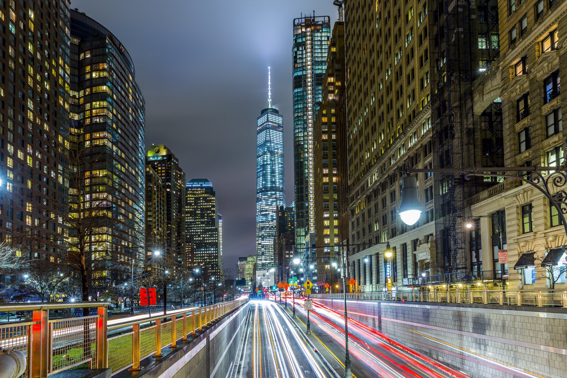 Nighttime time-lapse of Manhattan’s One World Trade Center and surrounding city buildings in New York, USA, captured as an HD PC desktop wallpaper and background.