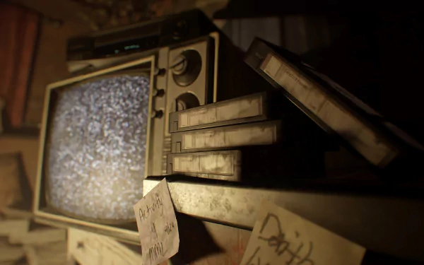 HD PC desktop wallpaper: moody Resident Evil 7: Biohazard scene — dusty CRT TV showing static, stacked VHS tapes and handwritten notes in a dim, decaying room.