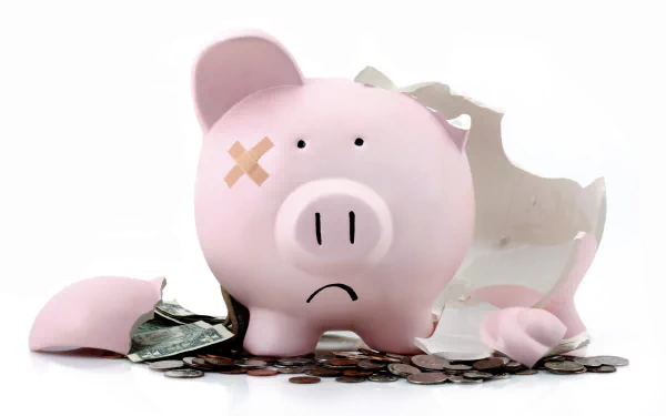A humorous 4K Ultra HD image of a sad pink man-made piggy bank with a bandage on its eye, cracked open with coins and dollar bills scattered around.