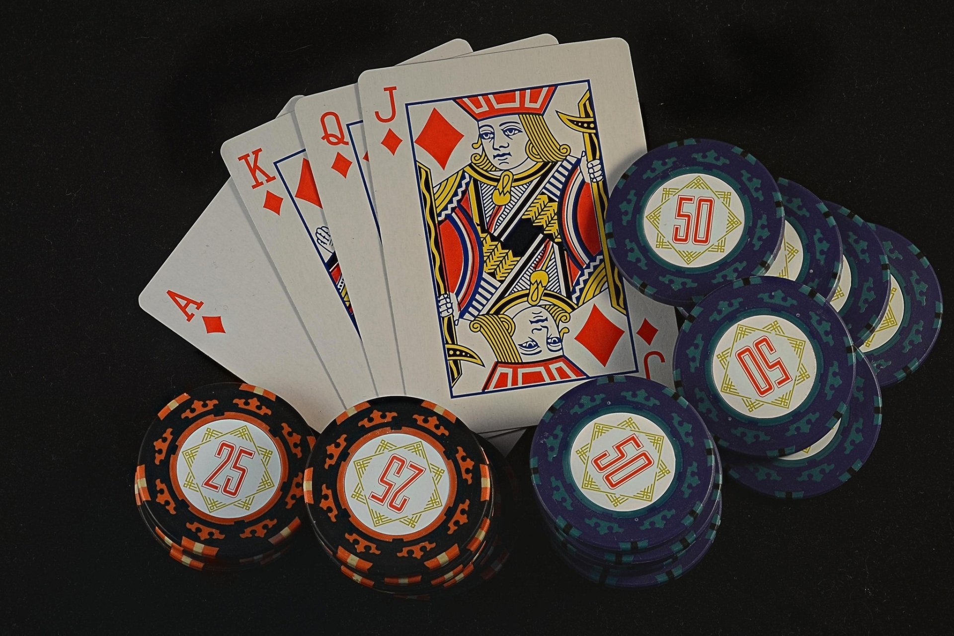 HD desktop wallpaper featuring a poker hand of four diamonds and poker chips on a dark background, highlighting man-made card game elements.