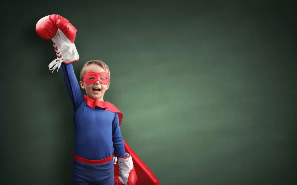 Child dressed as a superhero with a raised fist, posing for a vibrant HD desktop wallpaper.