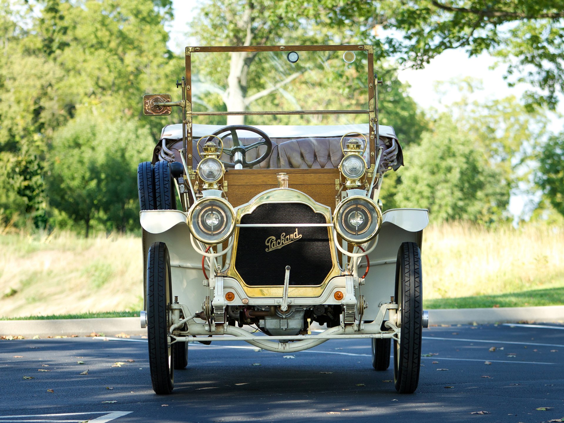 Front view of a cream 1909 Packard Model 18 Touring vintage car on a tree-lined road — HD PC desktop wallpaper