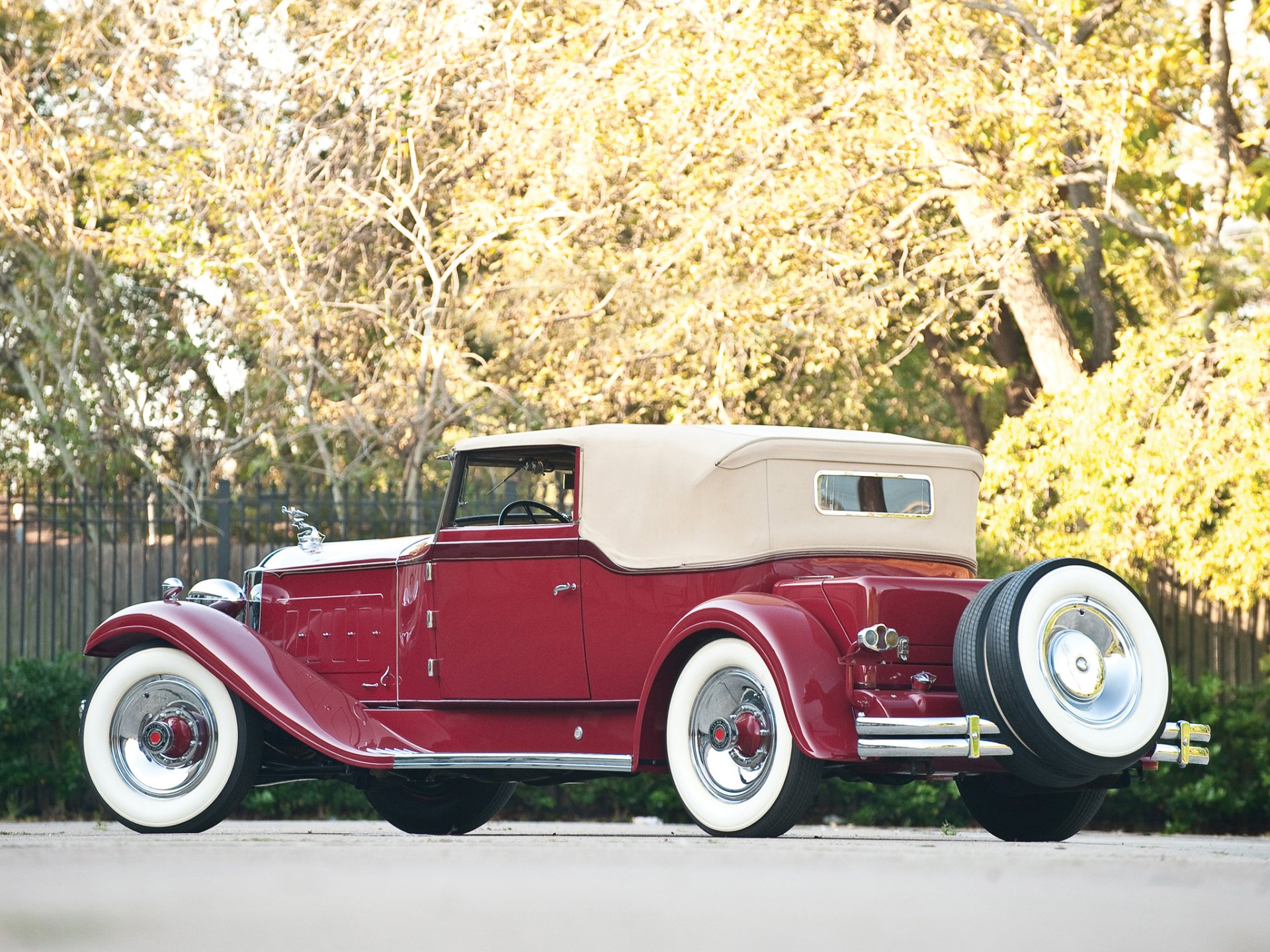Red 1931 Packard Deluxe Eight Convertible Victoria vintage car with tan soft top and whitewall tires, HD desktop wallpaper background.