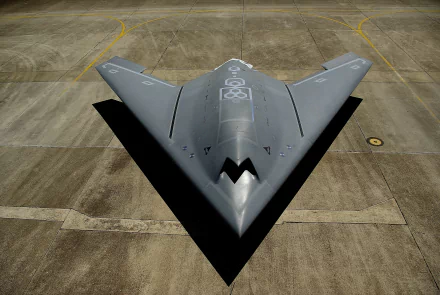 A top view of the Dassault nEUROn, a sleek military drone, showcased on the tarmac. This high-tech warplane emphasizes advanced design and drone technology. 4K Ultra HD wallpaper.