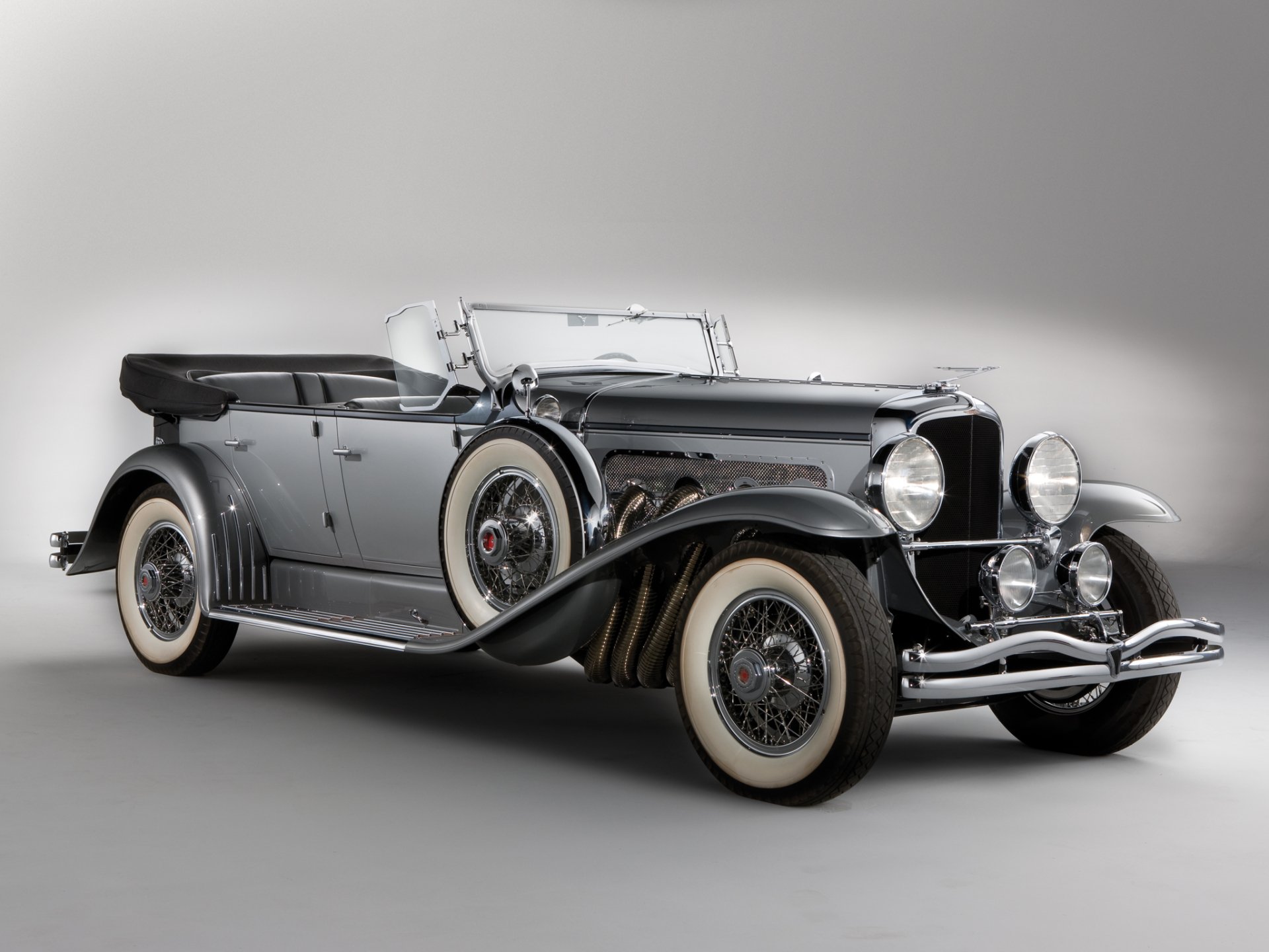 HD desktop wallpaper featuring a sleek vintage 1929 Duesenberg Model J Dual Cowl Phaeton, showcasing classic design and elegance in a stunning vehicle profile.