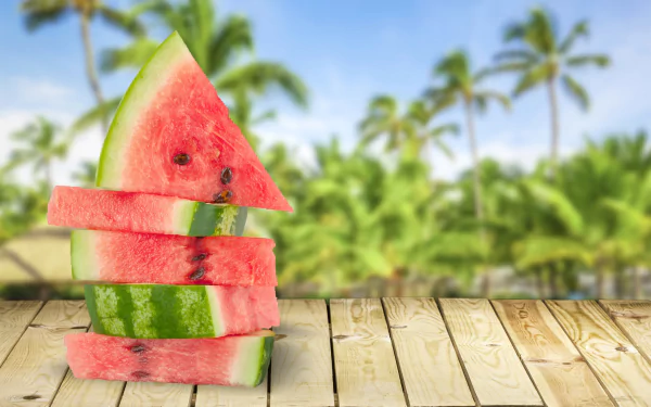 4K Ultra HD desktop wallpaper featuring stacked slices of juicy watermelon on a wooden surface with blurred palm trees in the background.
