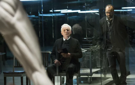 Bernard Lowe and Robert Ford, portrayed by Jeffrey Wright and Anthony Hopkins, sit in a reflective, high-tech environment from the TV show Westworld. An intriguing moment captured in HD wallpaper.