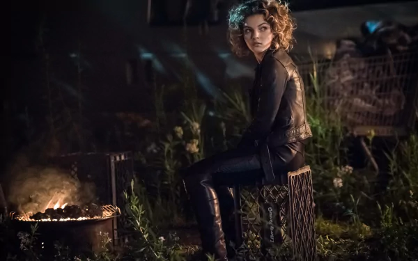Camren Bicondova as Catwoman (Selina Kyle) in Gotham TV show, sitting by a fire in a dark, outdoor setting. 4K Ultra HD PC desktop wallpaper.