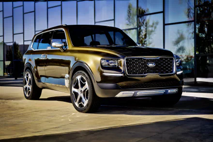 2K Quad HD desktop wallpaper: metallic Kia Telluride SUV parked before a glass building, shown in a front three-quarter view.
