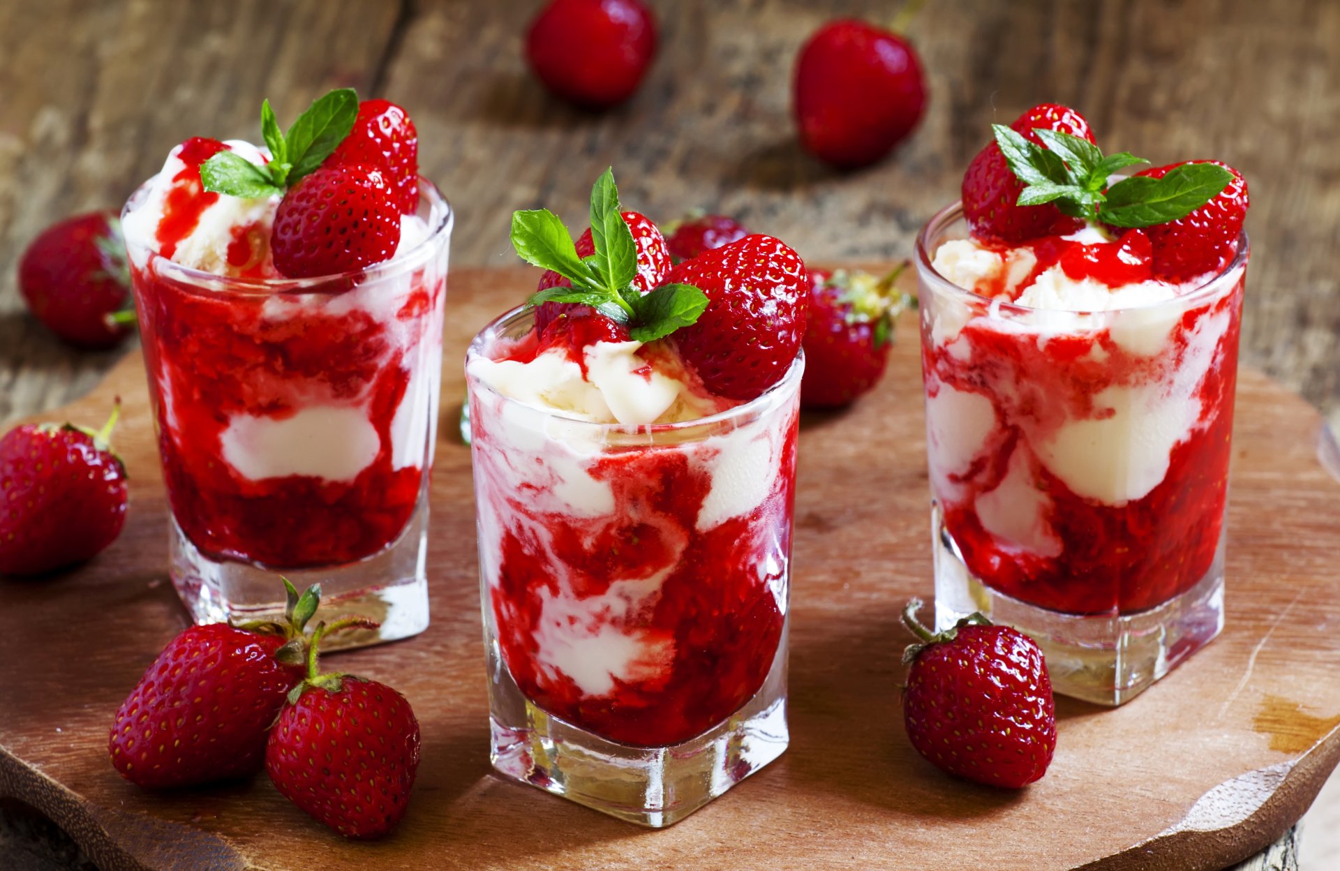 Three glasses of strawberry dessert with creamy layers and fresh strawberries on top, captured in vibrant 4K Ultra HD detail for a PC desktop wallpaper background.
