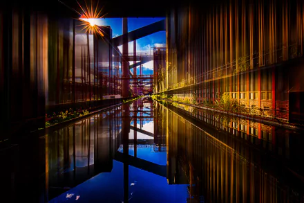 HD desktop wallpaper showcasing a vibrant factory building beside a canal, with striking reflections and warm lighting enhancing the urban industrial photography scene.