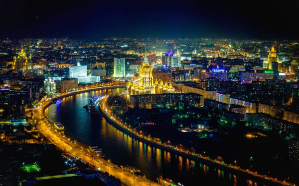 A stunning aerial view of Moscow at night, showcasing the illuminated cityscape along the river horizon, highlighting the vibrant lights of this man-made marvel in Russia.