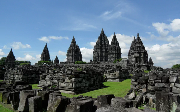 4K Ultra HD image of the ancient Hindu Prambanan Temple ruins, showcasing its towering religious stone structures under a bright blue sky.