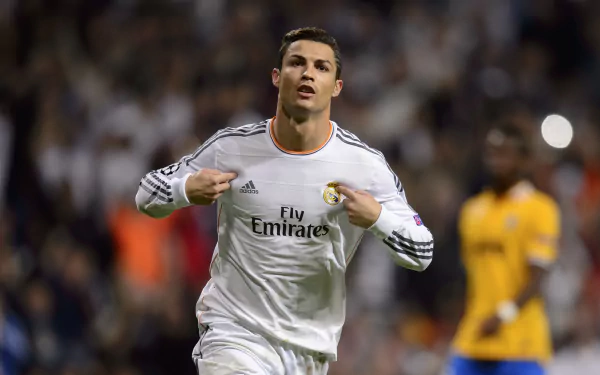Cristiano Ronaldo, in Real Madrid C.F. kit, celebrates during a soccer match. This HD desktop wallpaper captures the Portuguese star in action on the field.
