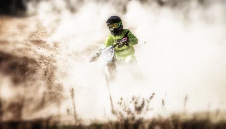 A motocross rider maneuvers through a cloud of dirt, showcasing the excitement of the sport in this high-definition desktop wallpaper and background.