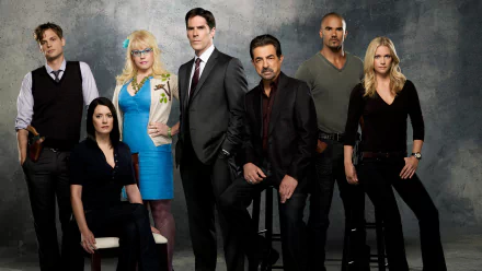 A group of main characters from the TV show Criminal Minds poses together, showcasing their distinct personalities and roles, set against a textured gray background.