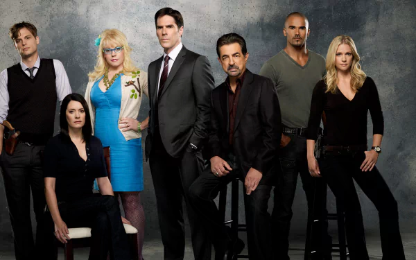 A group of main characters from the TV show Criminal Minds poses together, showcasing their distinct personalities and roles, set against a textured gray background.