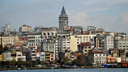 HD desktop wallpaper featuring the historic Galata Tower and surrounding buildings in Istanbul under a cloudy sky.