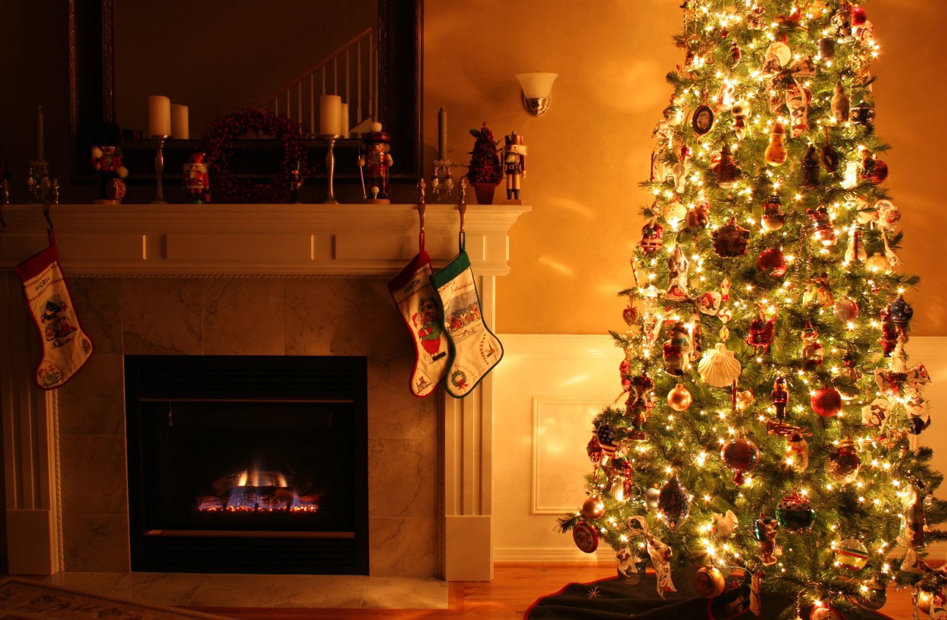 Cozy holiday scene with a lit fireplace, glowing Christmas tree adorned with ornaments and lights, and stockings hung on the mantle, captured in HD desktop wallpaper quality.