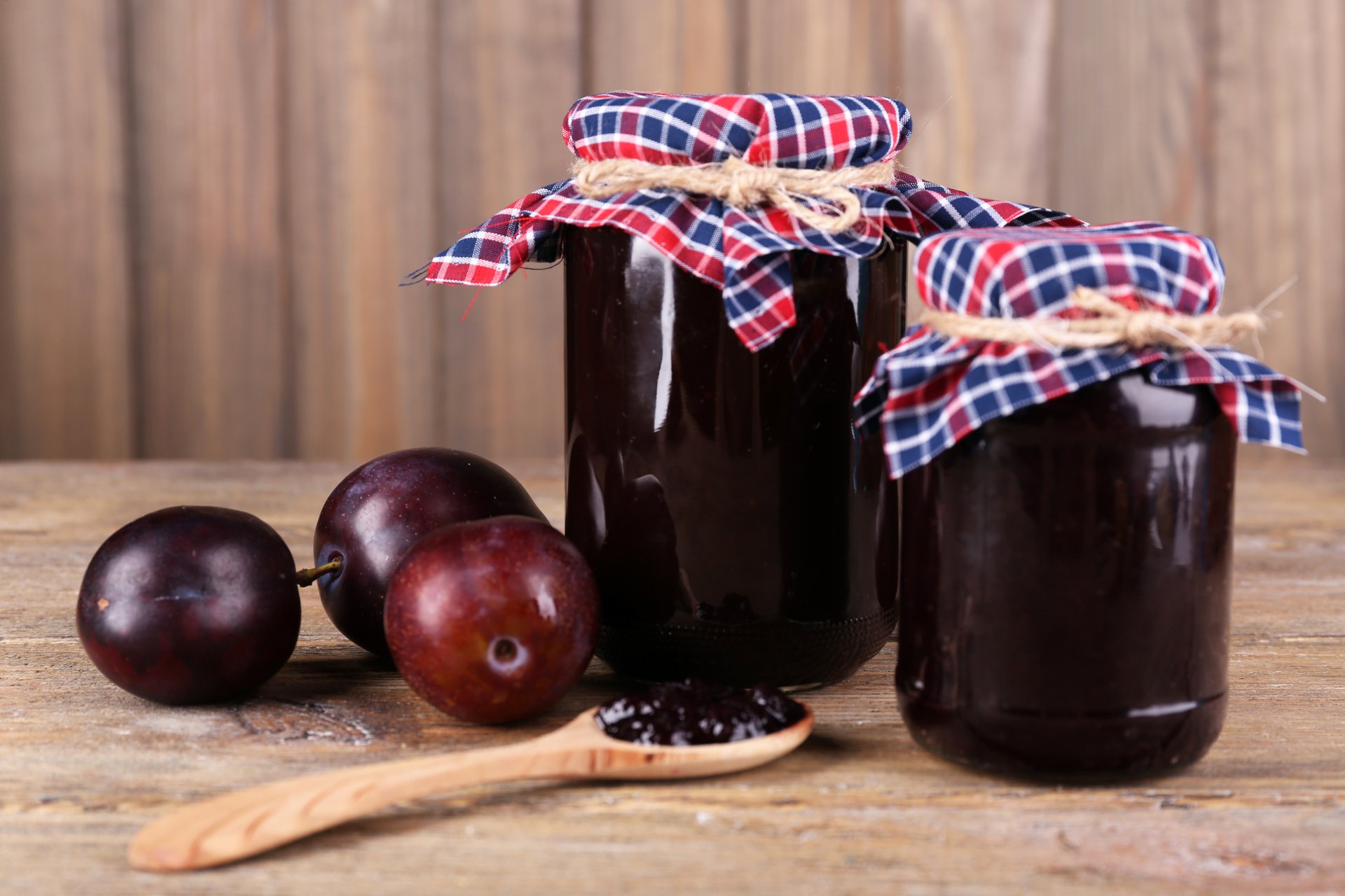 4K Ultra HD PC desktop wallpaper and background: jars of homemade plum jam with whole plums and a spoon on a rustic wooden table.