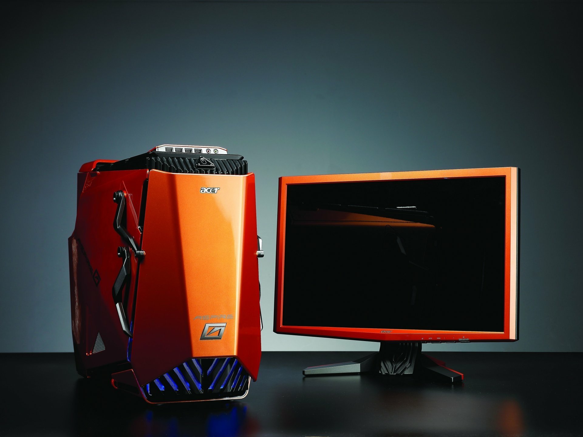 Acer desktop computer with an orange tower and matching monitor, displayed against a dark background as an HD PC desktop wallpaper and technology-themed image.