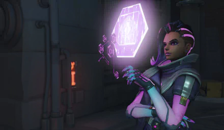 Sombra from Overwatch stands confidently, holding a glowing purple hexagon, set against a dark, industrial background. This HD PC desktop wallpaper showcases the game's striking visuals.