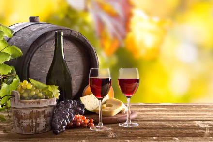 Still life 4K wallpaper featuring a wine barrel, bottle, two glasses of red wine, cheese, and grapes on a wooden table with a bright, blurred background.