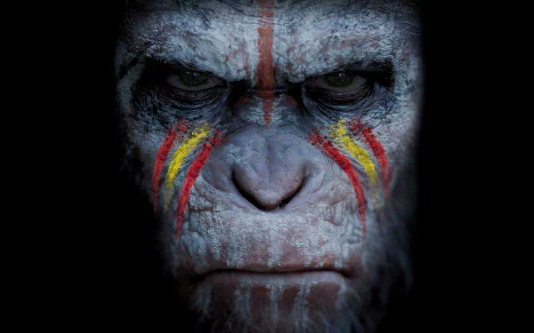HD PC desktop wallpaper: close-up of Caesar from the movie Dawn of the Planet of the Apes, stern face with red and yellow tribal paint on cracked gray skin, dark background.