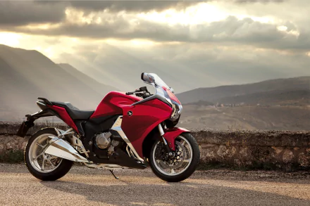 Red Honda VFR sport motorcycle vehicle parked on a scenic mountain road at sunset — high-resolution 4K Ultra HD PC desktop wallpaper background.