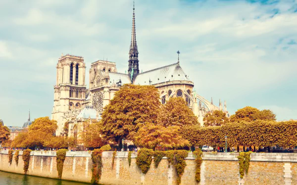 Notre-Dame de Paris cathedral on the Seine with autumn trees and blue sky — Parisian religious architecture rendered as a 5K Ultra HD PC desktop wallpaper.