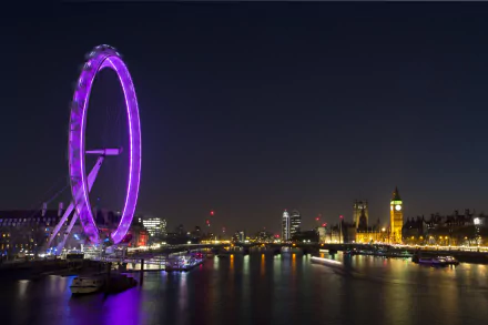 Night view of the illuminated London Eye ferris wheel and the city skyline along the Thames River in London, United Kingdom, captured in 4K Ultra HD.