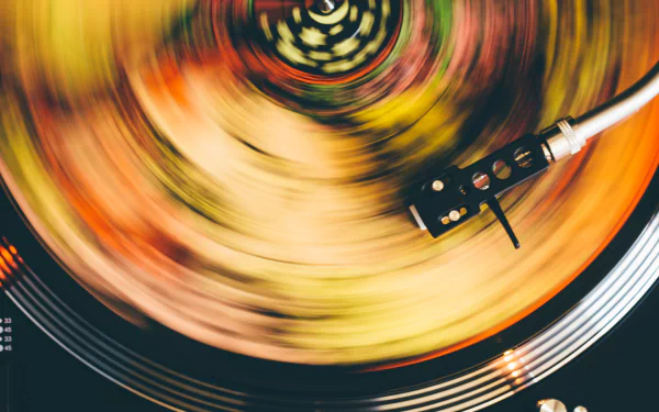 Close-up of a spinning record with motion blur effect, highlighting the turntable needle and vibrant colors, designed as an HD PC desktop wallpaper.