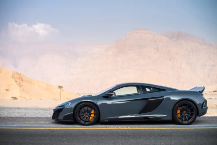 Silver McLaren 675LT supercar parked on a desert road with mountains in the background, showcased as an HD PC desktop wallpaper and background.